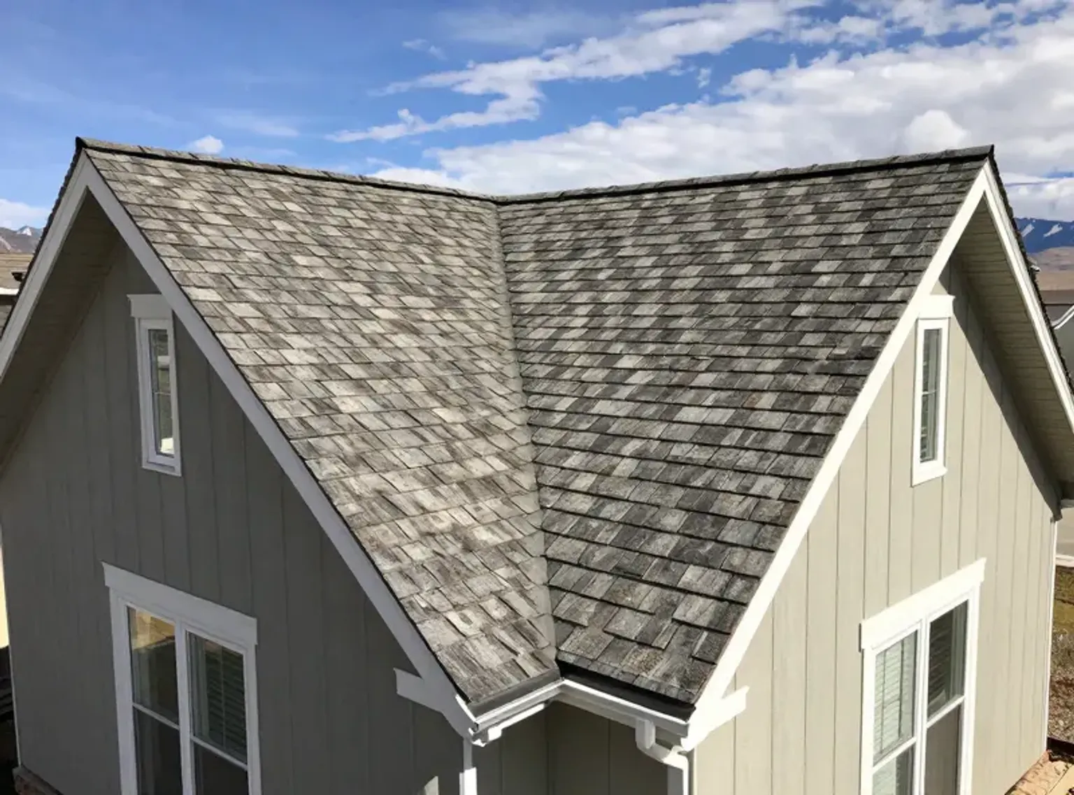 Documentary-style iPhone close-up of new architectural shingles installed on a Lehi Utah roof with clean coursing and nail line detail