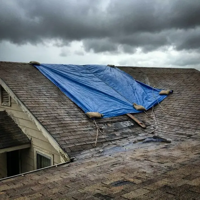 Emergency roofing crew securing a Lehi Utah home with tarping after storm damage with urgent response and natural daylight