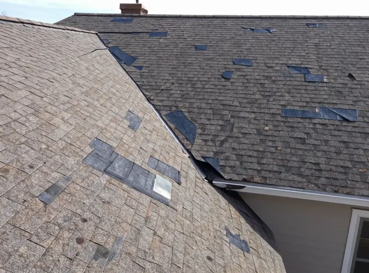 Documentary-style iPhone photo of hail-damaged shingles being replaced on a Lehi Utah home with new matching material